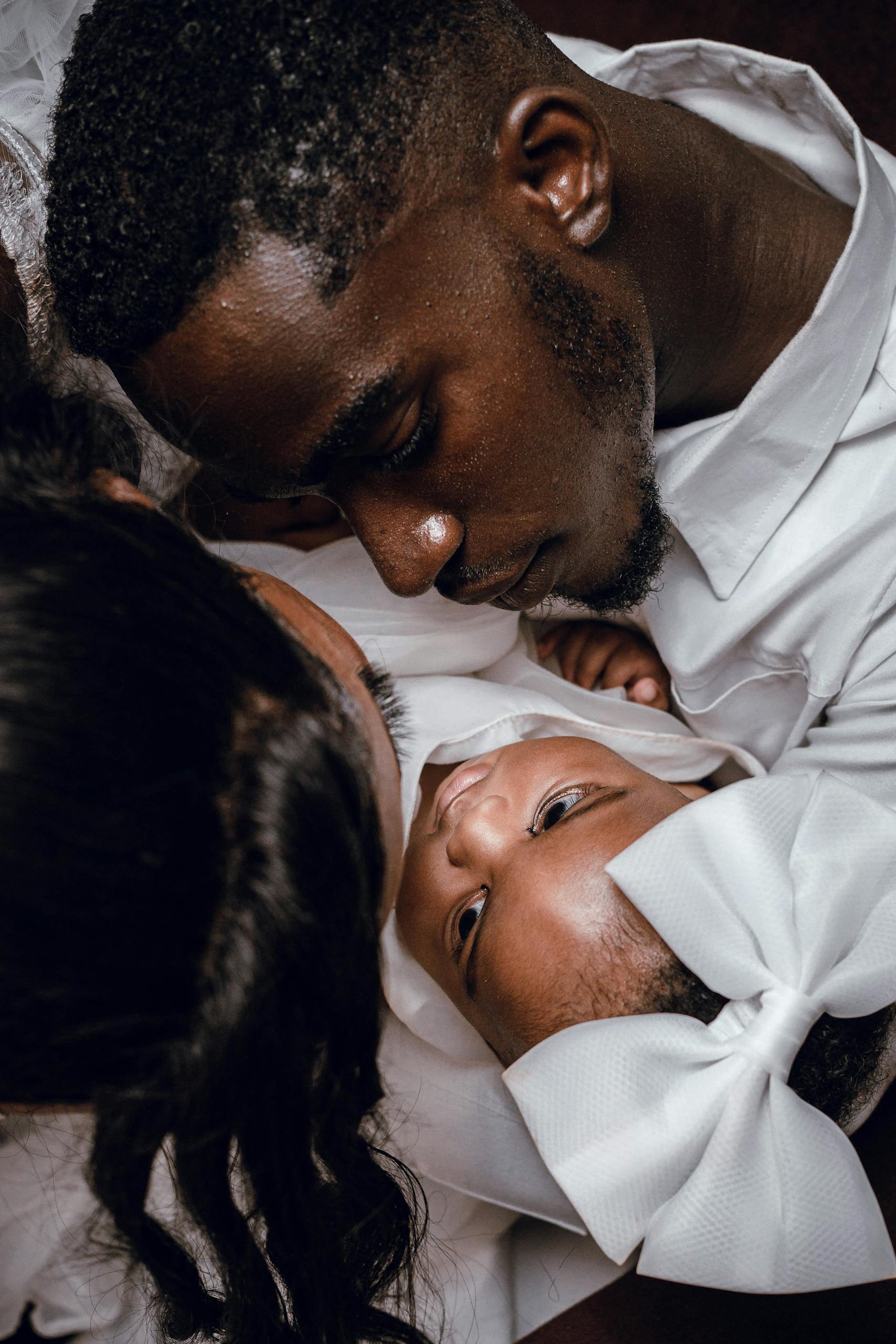 A touching moment between parents and baby showcasing family love and connection.