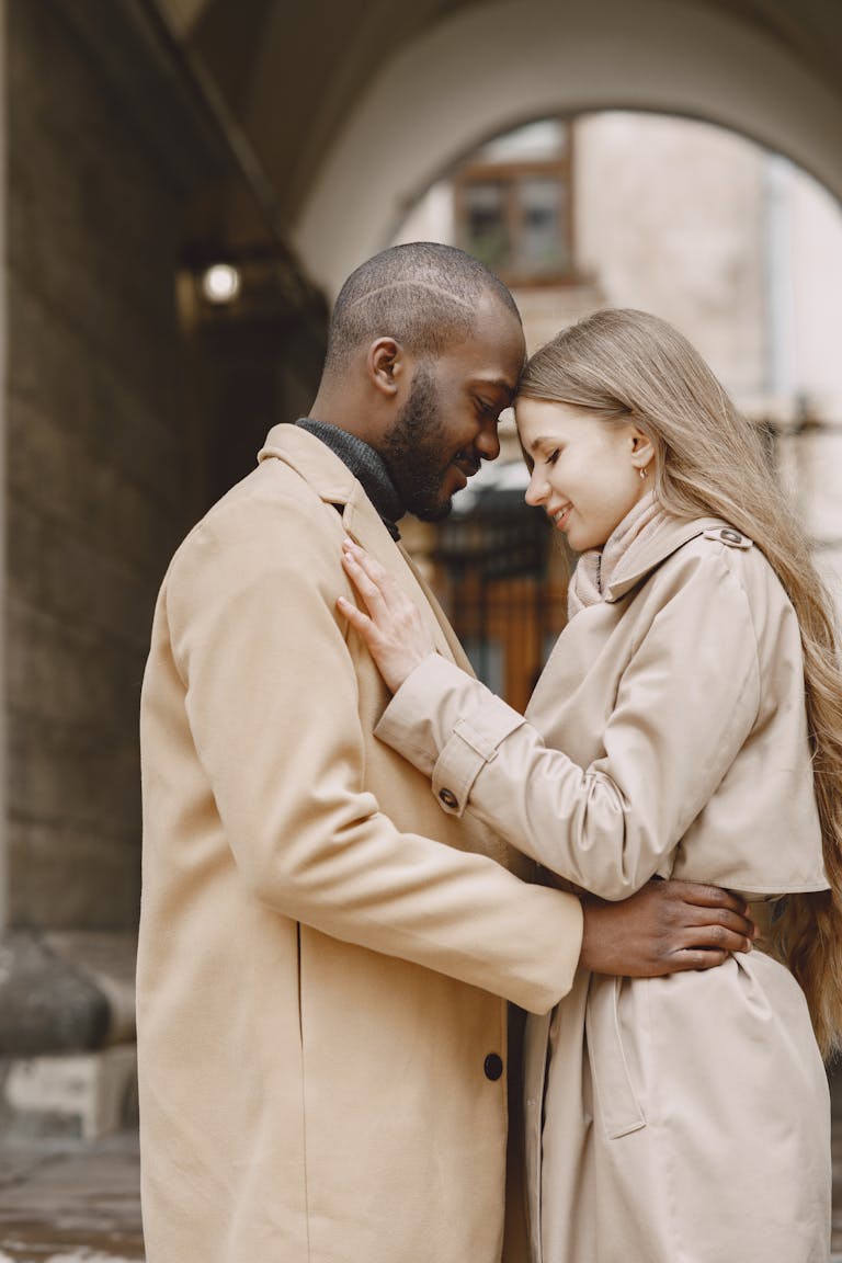 A couple sharing a tender embrace outdoors, highlighting love and affection.