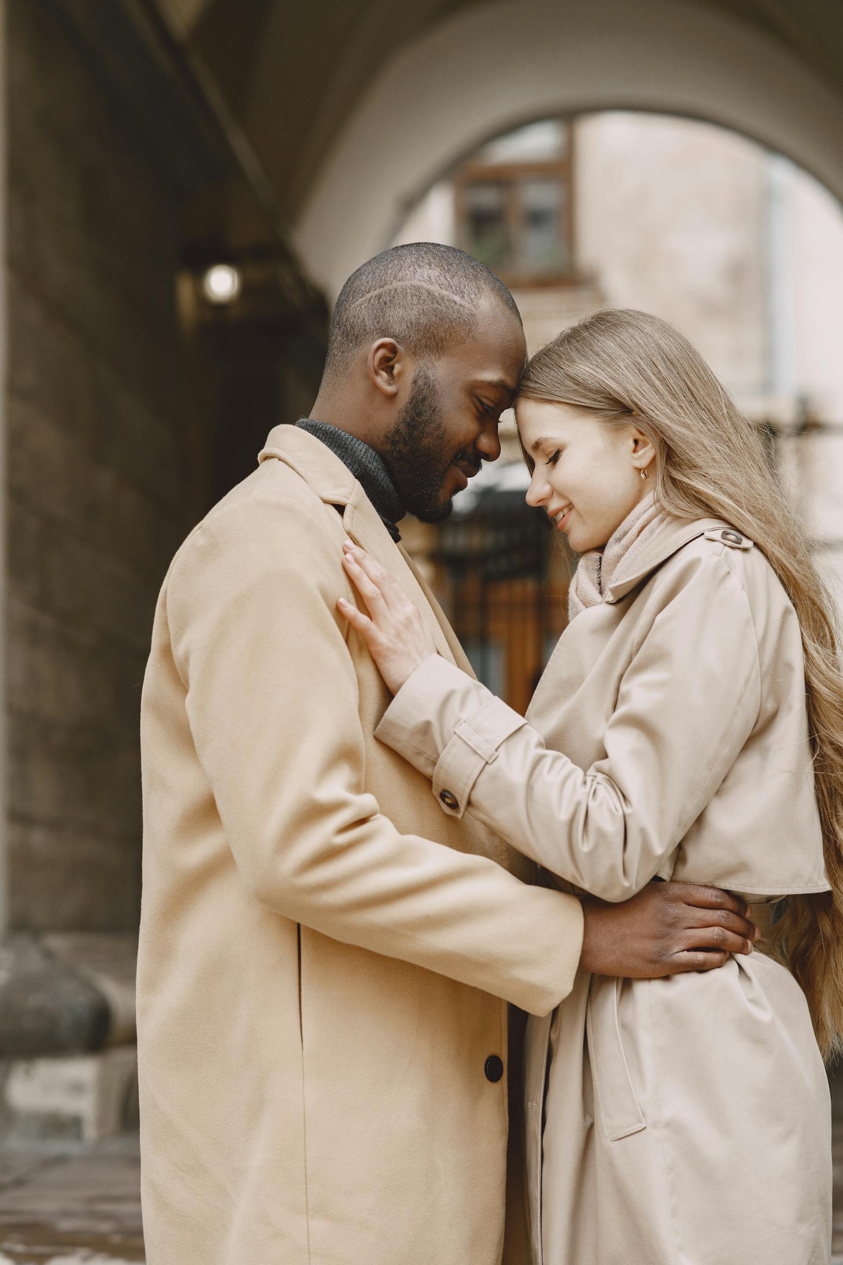 A couple sharing a tender embrace outdoors, highlighting love and affection.